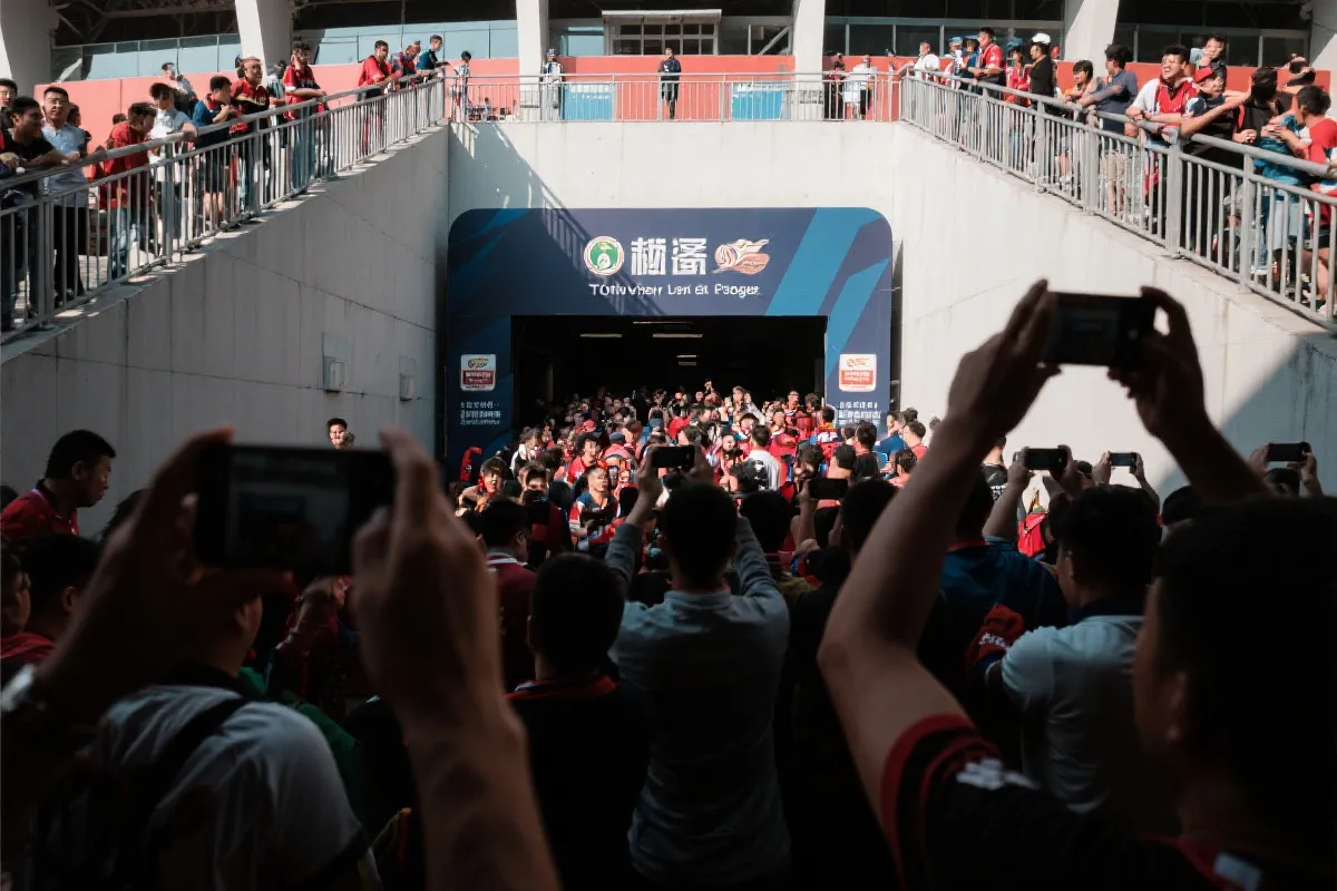 球迷在球场通道拍摄入场氛围，手机特写与人群光影